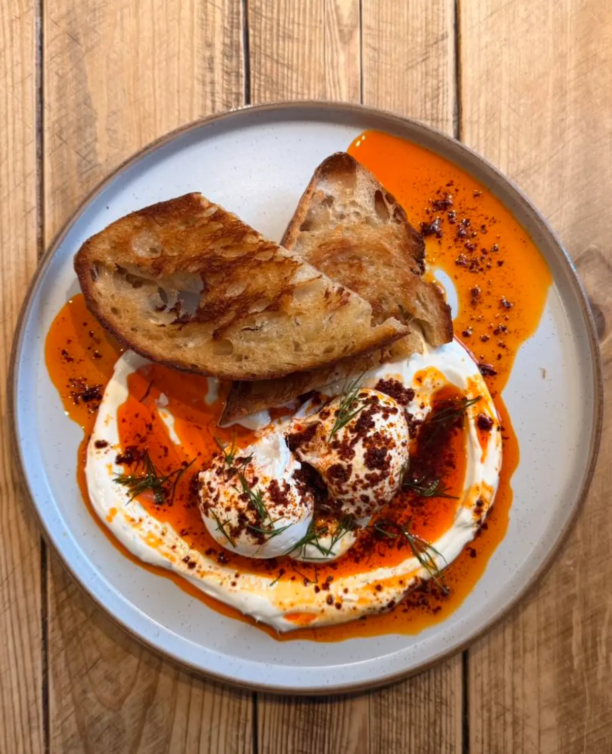 Poached eggs on garlic yogurt with chilli butter and toasted sourdough