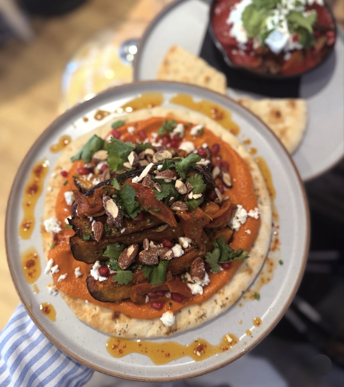 Sticky harissa aubergine with romesco hummus, pomegranate, feta and smoked almonds